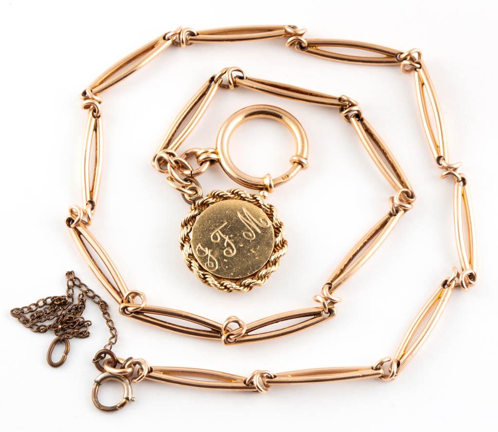 ANTIQUE 12K ROSE GOLD POCKET WATCH CHAIN WITH 14K: ANTIQUE 12K ROSE GOLD POCKET WATCH CHAIN WITH 14K YELLOW GOLD LOCKET, fetter-type chain links, one end having a large spring ring clasp and a tested 14K yellow gold locket with engraved "J.F.M" initia