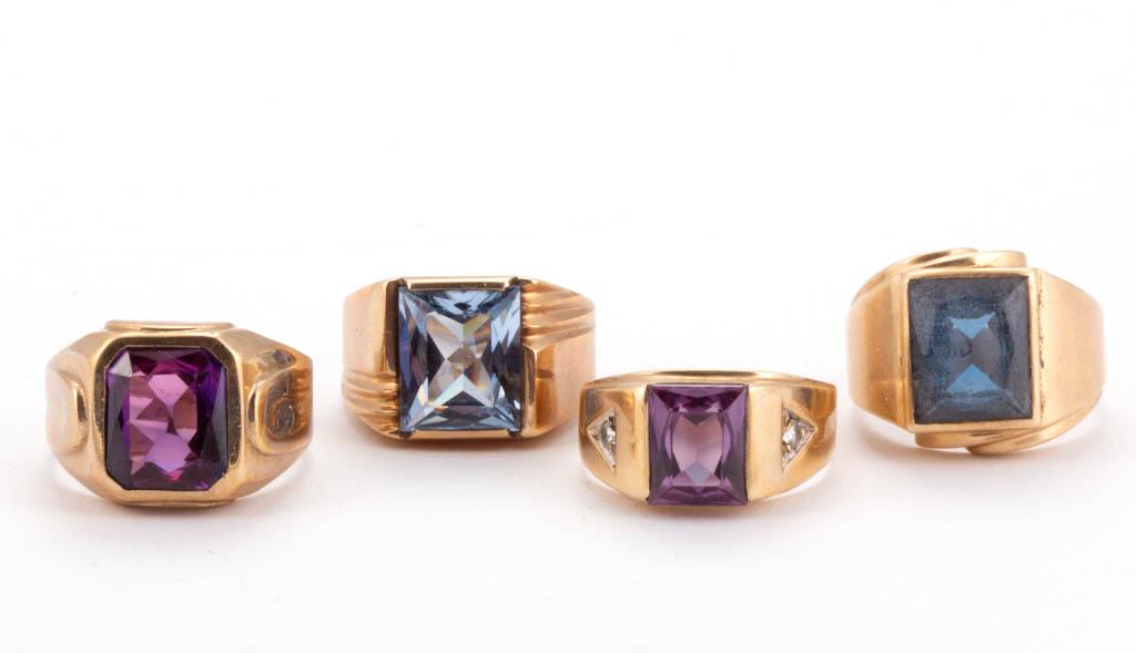 VINTAGE 10K YELLOW GOLD AND STONE MEN'S RINGS, LOT OF: VINTAGE 10K YELLOW GOLD AND STONE MEN'S RINGS, LOT OF FOUR, comprising two with blue spinel/topaz stones, one with an unidentified purple stone, and one with an unidentified multi-colored stone flanke