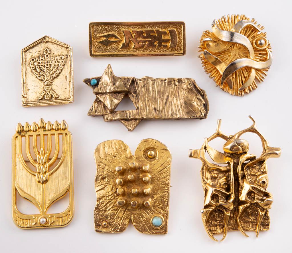 VINTAGE ISRAELI / JUDAICA GILT-METAL BROOCHES /: VINTAGE ISRAELI / JUDAICA GILT-METAL BROOCHES / PENDANTS, LOT OF SEVEN, including a Modernist/Brutalist example by Igael Tumarkin, an example with a turquoise-type cabochon and dated "76" by Dani Kara
