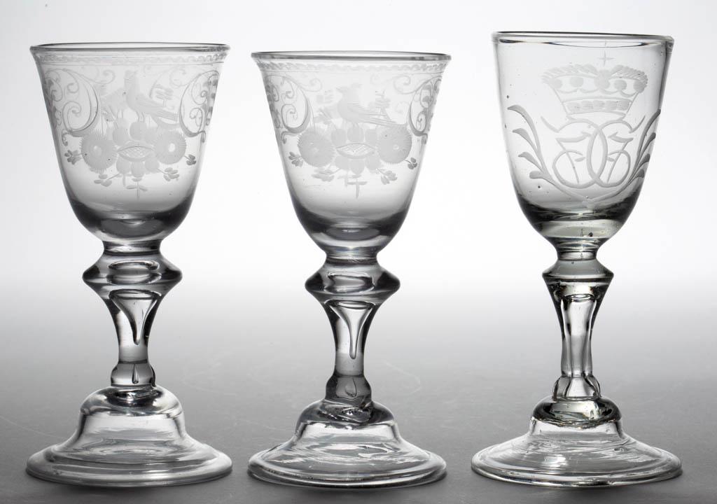 CONTINENTAL FREE-BLOWN AND ENGRAVED BALUSTER WINE: CONTINENTAL FREE-BLOWN AND ENGRAVED BALUSTER WINE GLASSES, LOT OF THREE, colorless non-lead glass, each with round funnel bowl, comprising one with a crown over monogram flanked with sprays, and a pai