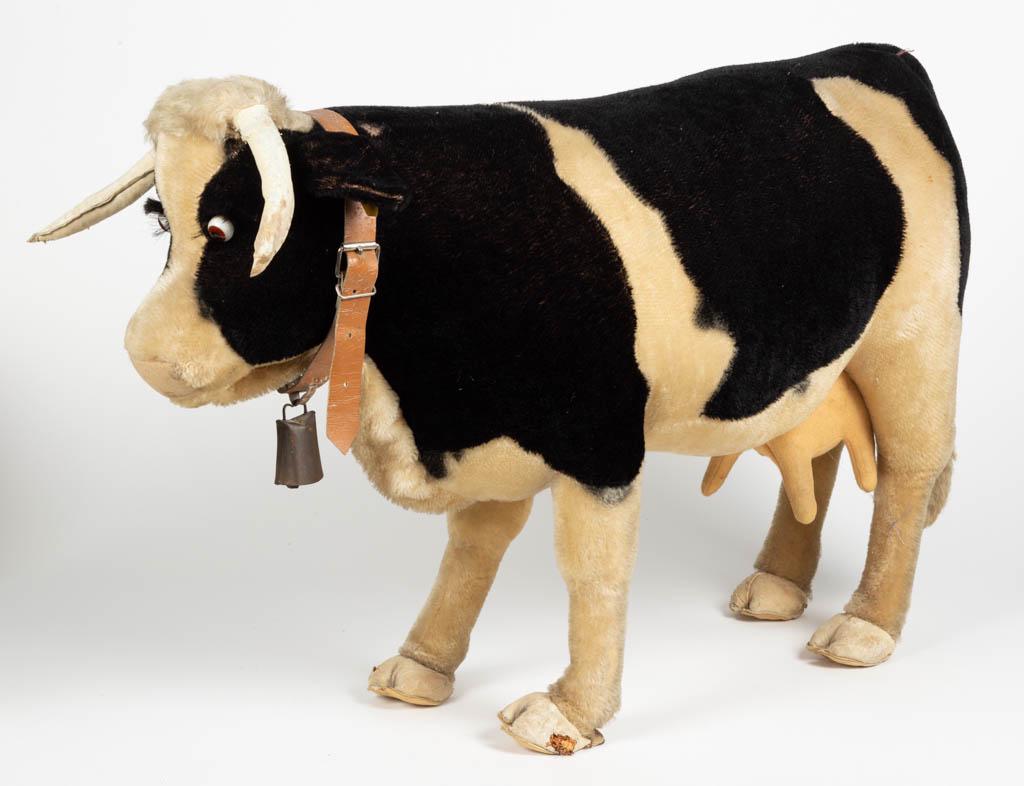RARE GERMAN STEIFF STUFFED HOLSTEIN COW TOY: RARE GERMAN STEIFF STUFFED HOLSTEIN COW TOY, mohair, standing with original yellow tag, marked "1365,90", glass eyes, felt udders, and leather collar with bell. Circa 1955. 21 1/4" HOA, 33" LOA.Good o