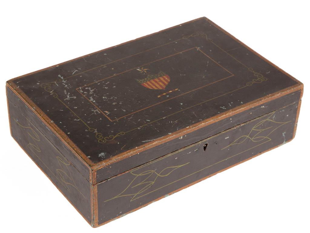 AMERICAN PAINT-DECORATED POPLAR DOCUMENT BOX: AMERICAN PAINT-DECORATED POPLAR DOCUMENT BOX, rectangular form with hinged lid and blue paper-lined interior, decoration featuring pinstriping and polychrome Federal shield to lid. Mid 19th century. 1
