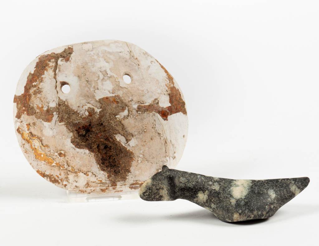NATIVE AMERICAN ARTIFACTS, LOT OF TWO: NATIVE AMERICAN ARTIFACTS, LOT OF TWO, comprising a carved granite birdstone and a shell gorget, each with drilled holes. Birdstone 3 1/2" L.Gorget in excavated condition, birdstone excellent.Provenan