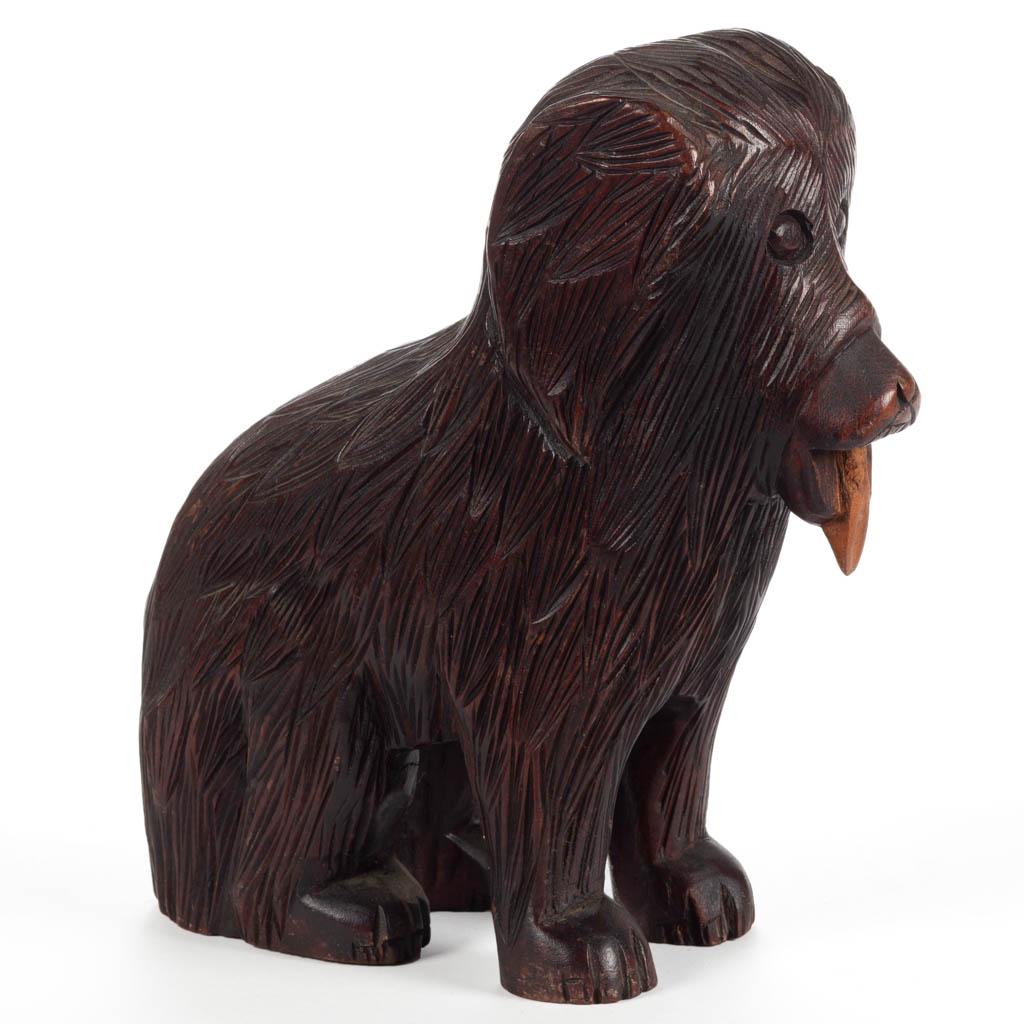 FOLK ART CARVED WOODEN DOG: FOLK ART CARVED WOODEN DOG, depicting a seated shaggy dog with tongue hanging out, illegible stamp mark to the underside. Original surface with warm color. First half 20th century. 8 1/2" H.Very good