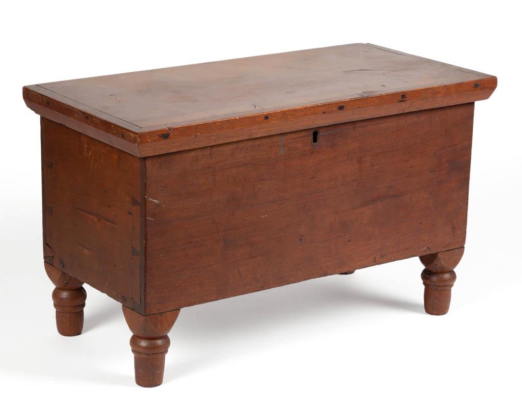 AMERICAN CHERRY AND WALNUT MINIATURE BLANKET CHEST: AMERICAN CHERRY AND WALNUT MINIATURE BLANKET CHEST, the hinged lid with applied moldings over a dovetailed case raised on applied turned feet. Poplar secondary wood. Early surface with rich color. Sec