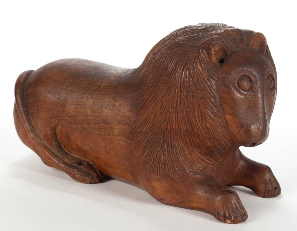 AMERICAN FOLK ART CARVED FIGURE OF A LION: AMERICAN FOLK ART CARVED FIGURE OF A LION, expressive reclining form retaining early surface with warm color. Possibly Ohio. Second half 19th century. 5 3/4" HOA, 9 1/2" LOA. Minor wear and losses to 