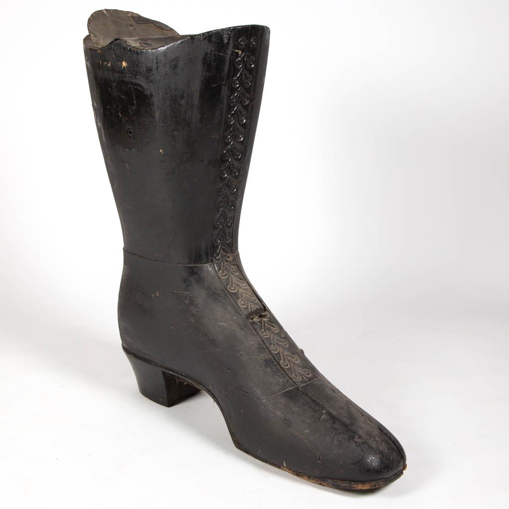 FOLK ART PAINTED WOODEN TRADE SIGN: FOLK ART PAINTED WOODEN TRADE SIGN, laminated construction, in the form of a ladies shoe, top of shoe with applied tin. Retains an old black-painted surface. Fourth quarter 19th/early 20th century. 34