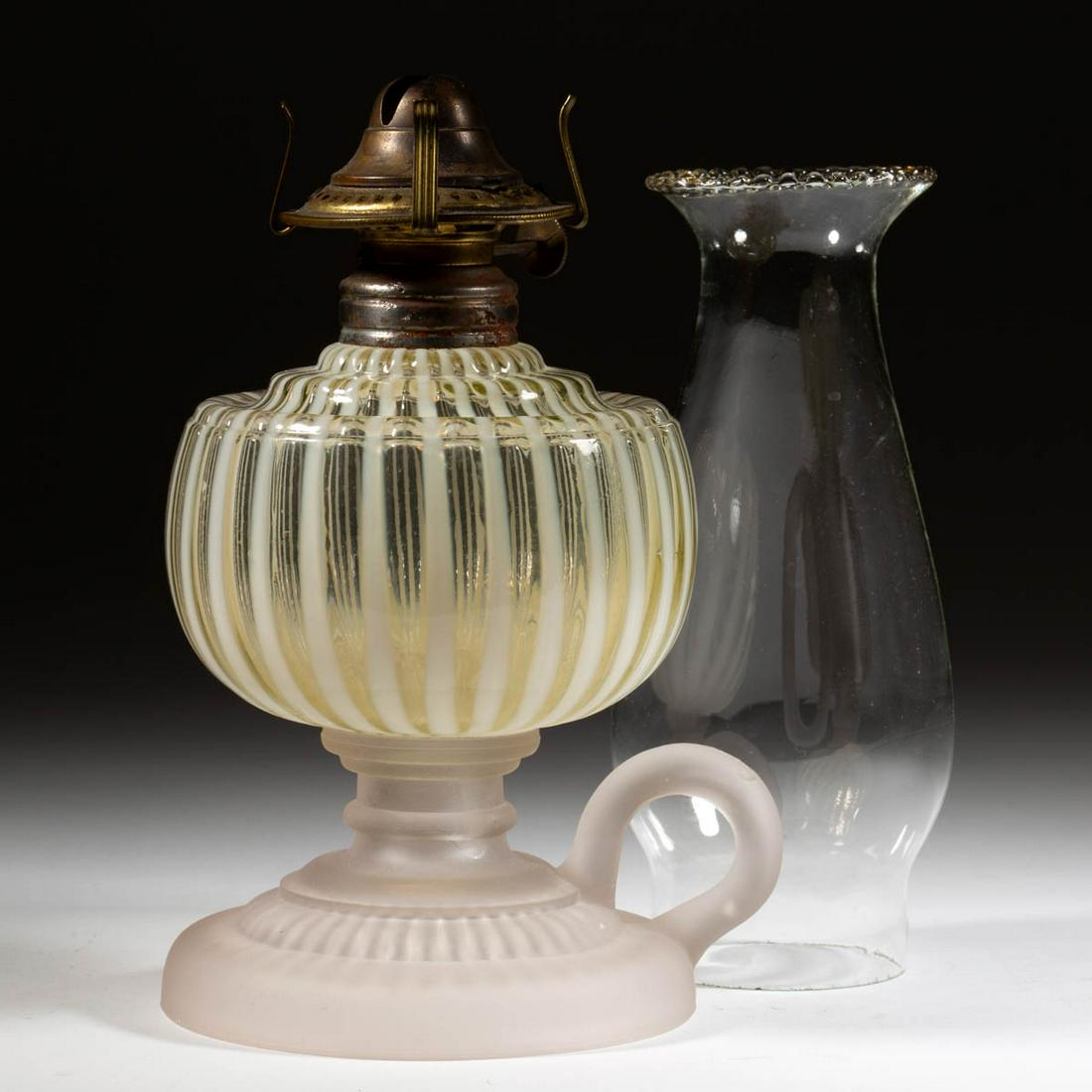 VENETIAN / VENICE KEROSENE FOOTED FINGER LAMP: VENETIAN / VENICE KEROSENE FOOTED FINGER LAMP, Vaseline (reacts under black light) opalescent stripe font, drip-guard shoulder, frosted colorless base with molded handle, No. 1 steel collar. Fitted wi