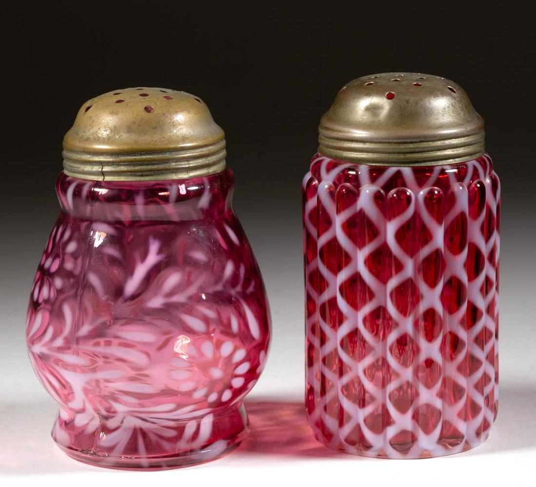 ASSORTED OPALESCENT GLASS SUGAR SHAKERS, LOT OF TWO: ASSORTED OPALESCENT GLASS SUGAR SHAKERS, LOT OF TWO, cranberry opalescent, comprising a Daisy and Fern and a Ribbed Opal Lattice, each having a period lid. Various makers. Late 19th/early 20th century