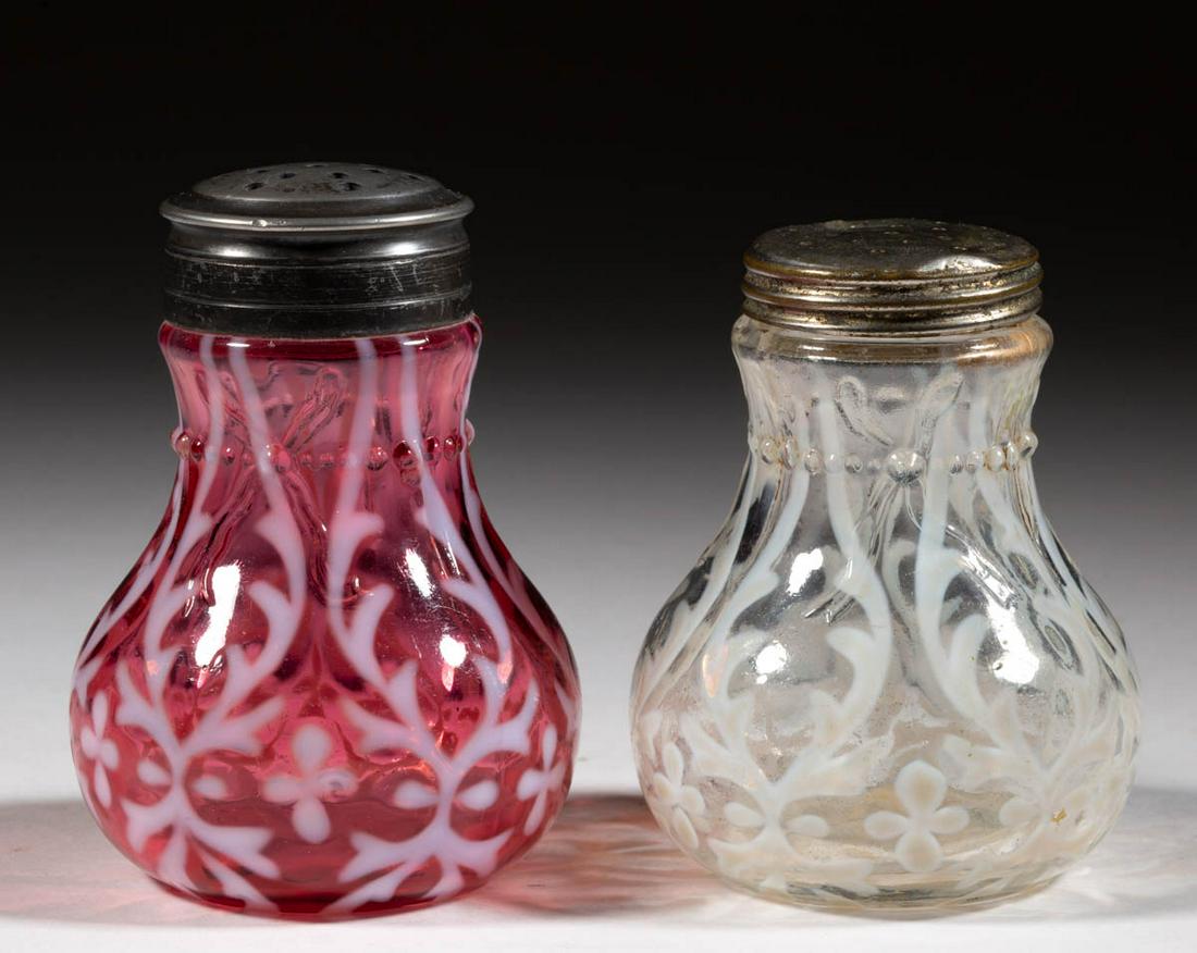 OPALINE BROCADE / SPANISH LACE - RIBBON-TIE MOLD SALT: OPALINE BROCADE / SPANISH LACE - RIBBON-TIE MOLD SALT AND PEPPER SHAKERS, LOT OF TWO, colorless opalescent and cranberry opalescent, each having a period lid. Northwood Glass Co. Pattern introduced in