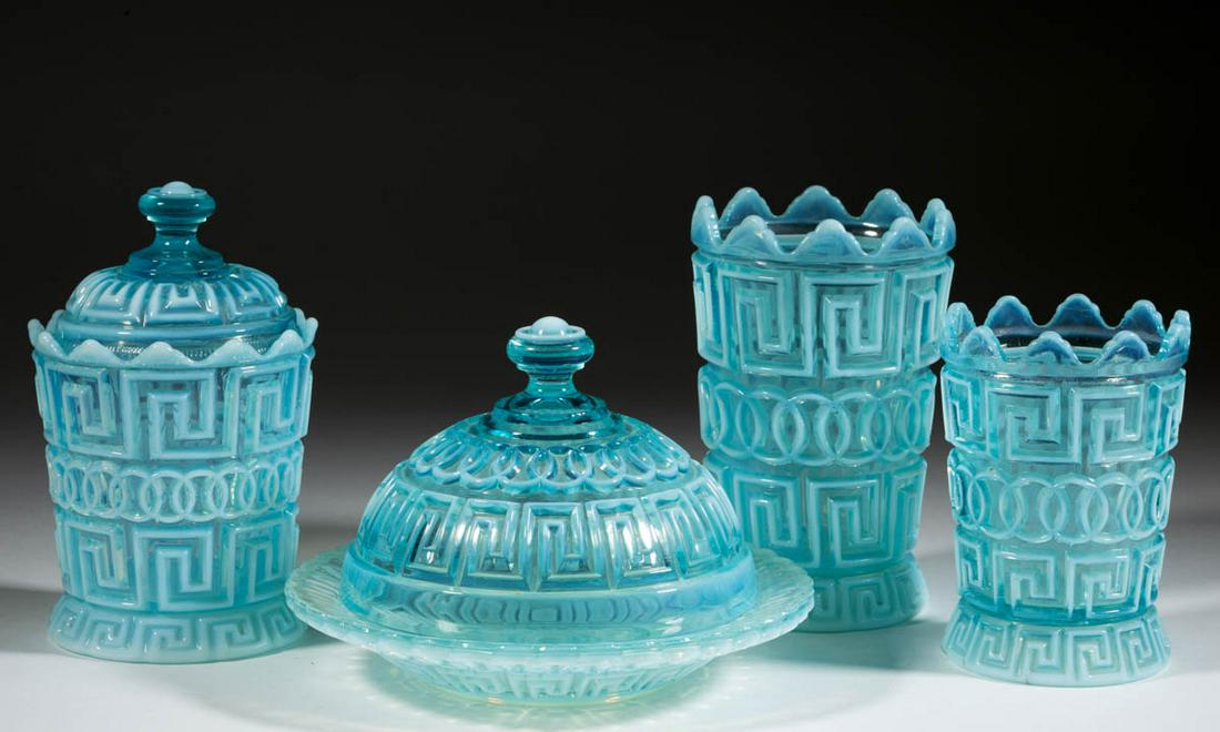 DOUBLE GREEK KEY TABLE ARTICLES, LOT OF FOUR: DOUBLE GREEK KEY TABLE ARTICLES, LOT OF FOUR, blue opalescent, comprising a butter dish, celery vase, covered sugar, and spooner. Nickel Plate Glass Co. Circa 1892. 5" to 6 1/2" HOA. 8 1/8" HOA.Sugar