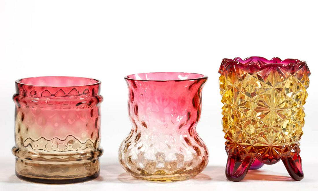 ASSORTED AMBERINA GLASS TOOTHPICK HOLDERS, LOT OF THREE: ASSORTED AMBERINA GLASS TOOTHPICK HOLDERS, LOT OF THREE, comprising a three-foot Daisy and Button, a ringed barrel-form, and a bulbous-base form, two having a factory-polished rim. Various makers. Fou