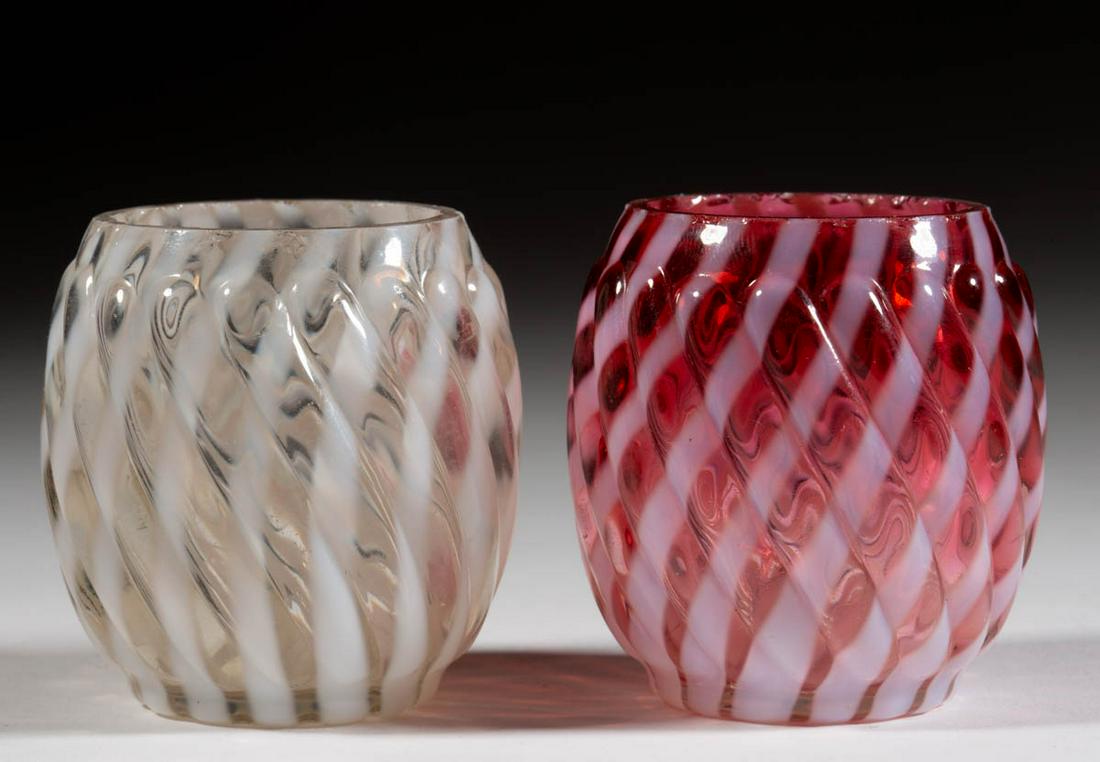 REVERSE SWIRL TOOTHPICK HOLDERS, LOT OF TWO: REVERSE SWIRL TOOTHPICK HOLDERS, LOT OF TWO, colorless opalescent and cranberry opalescent, each having a factory-polished rim. Maker unverified. 1888-1902. 2 1/8" H. Cranberry undamaged; colorless ha