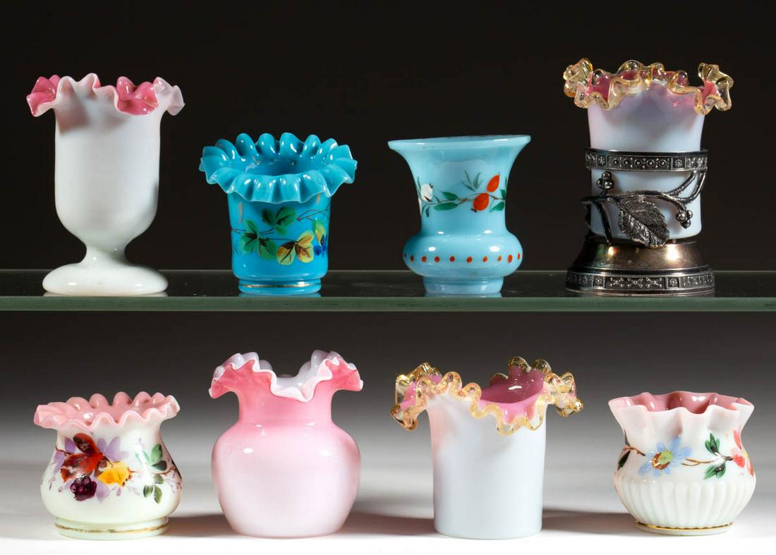 ASSORTED OPAQUE GLASS TOOTHPICK HOLDERS, LOT OF EIGHT: ASSORTED OPAQUE GLASS TOOTHPICK HOLDERS, LOT OF EIGHT, comprising two opaque blue, five opaque pink to opaque white, and a Peachblow-type, one being fitted into a quadruple-plate stand. Various makers