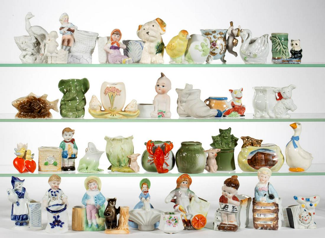 ASSORTED PORCELAIN FIGURAL TOOTHPICK / MATCH HOLDERS,: ASSORTED PORCELAIN FIGURAL TOOTHPICK / MATCH HOLDERS, LOT OF 35, including one example with a standing child and chicken beside a stump with striker to side, a panda sitting beside bamboo, a piglet re