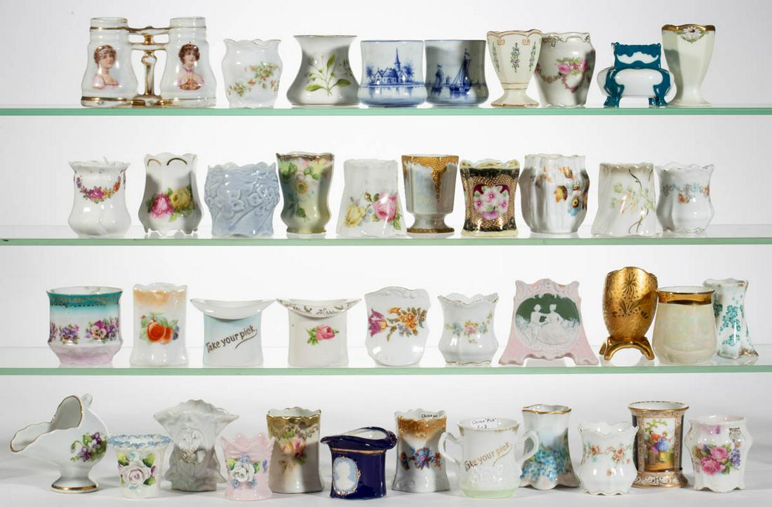 GERMAN PORCELAIN TOOTHPICK HOLDERS, LOT OF 41: GERMAN PORCELAIN TOOTHPICK HOLDERS, LOT OF 41, including a squat-form example with teal overlay, a triangular pink bisque example with central medallion featuring a dancing couple, a binocular-form ex