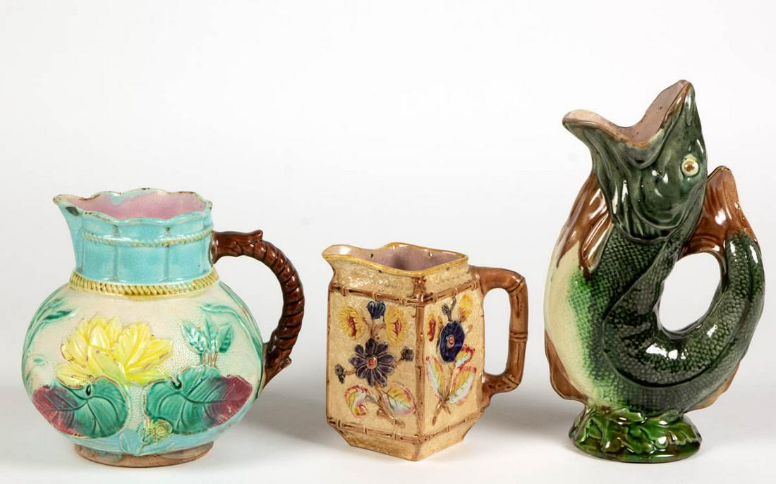 MAJOLICA CERAMIC PITCHERS, LOT OF THREE: MAJOLICA CERAMIC PITCHERS, LOT OF THREE, each having bright polychrome enamel decorations, comprising a molded fish example with gaping mouth, a globular-shaped Samuel Lear-attributed example with rel