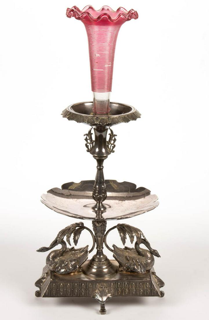 MERIDEN SILVER PLATE CO. SILVER-PLATED CENTERPIECE /: MERIDEN SILVER PLATE CO. SILVER-PLATED CENTERPIECE / EPERGNE, having a two-tiered top with a stem support, rectangular base with two swans under palm-type leaves, raised on four curved feet with leaf 