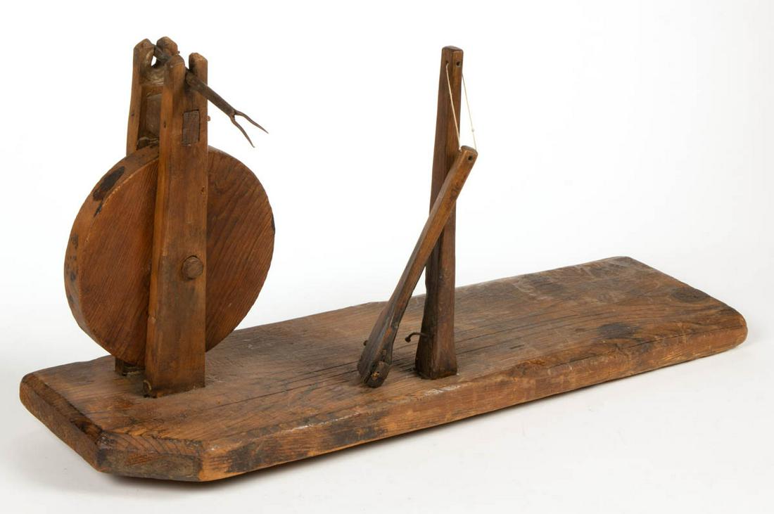 PRIMITIVE WOODEN APPLE PEELER: PRIMITIVE WOODEN APPLE PEELER, yellow pine and poplar, having mortise-and-tenon frame, iron fork, and metal blade. 19th century. 12 1/4" HOA, 24" L. Good as-found condition, lacking crank handle and o