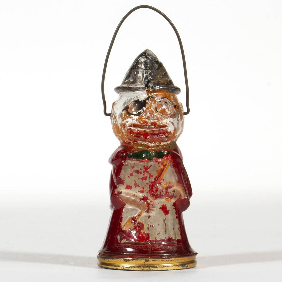 HALLOWEEN PUMPKIN HEAD FIGURAL GLASS CANDY CONTAINER: HALLOWEEN PUMPKIN HEAD FIGURAL GLASS CANDY CONTAINER, colorless with some paint, metal bail handle and screw closure. Circa 1920. 4 1/2" H figure. Undamaged. Losses to paint. Literature: Eikelberner/A