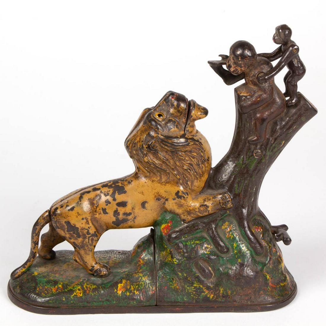 LION AND MONKEYS FIGURAL CAST-IRON MECHANICAL BANK: LION AND MONKEYS FIGURAL CAST-IRON MECHANICAL BANK, lion figure with glass eyes, marked "PAT JULY 17 / 83" to underside of base. Working condition with original paint. Kyser & Rex, Frankfort, PA. Circ