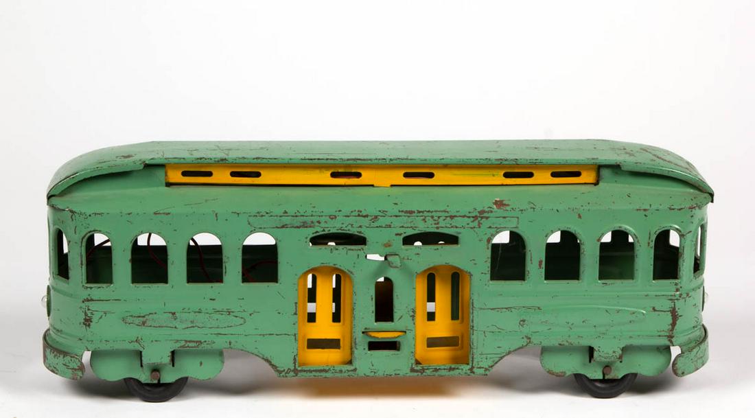 PRESSED-STEEL TOY TRAIN PASSENGER CAR: PRESSED-STEEL TOY TRAIN PASSENGER CAR, with two lever-operated working doors, battery-powered light to each end, and hard-rubber tires. No markings located. Circa 1930. 7 1/2" H, 20 1/2" L. Good as-fo