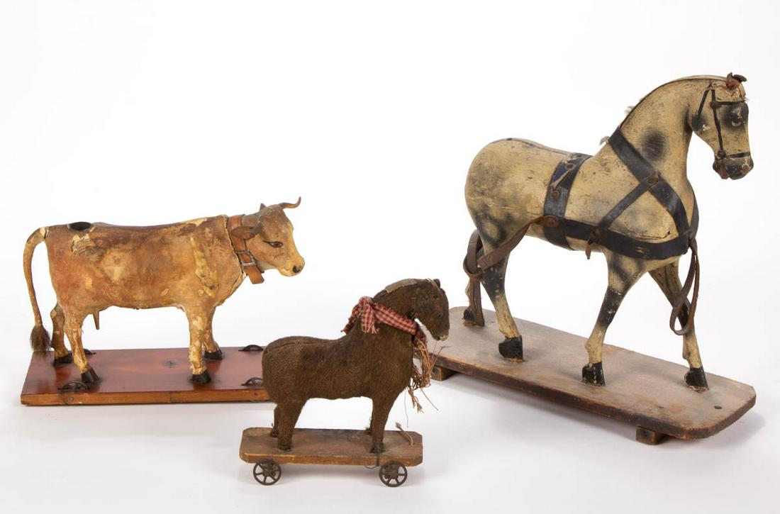 ANTIQUE FIGURAL ANIMAL PULL TOYS, LOT OF THREE: ANTIQUE FIGURAL ANIMAL PULL TOYS, LOT OF THREE, comprising German composition mooing cow, carved and painted horse, and fabric covered horse. Fourth quarter 19th/first quarter 20th century. Painted Ho