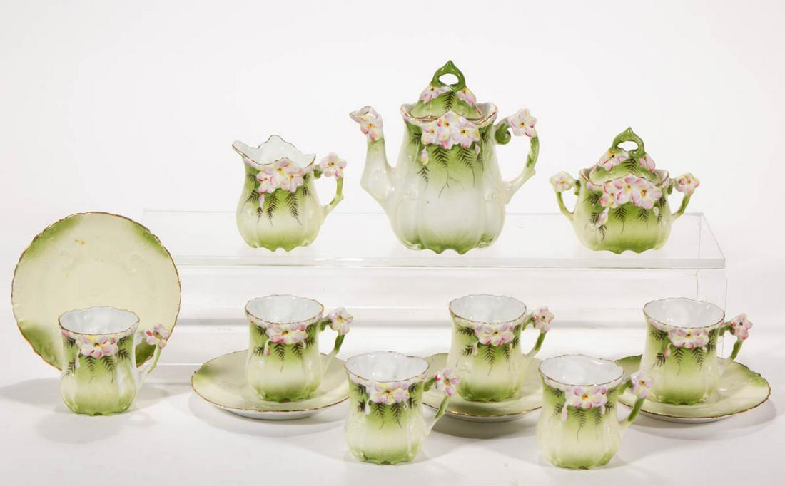 R.S. PRUSSIA PORCELAIN 13-PIECE CHILD'S TEA SET: R.S. PRUSSIA PORCELAIN 13-PIECE CHILD'S TEA SET, comprising a teapot, a creamer, a covered sugar, six cups, and four saucers, each featuring charming molded pink and yellow floral design on light gree