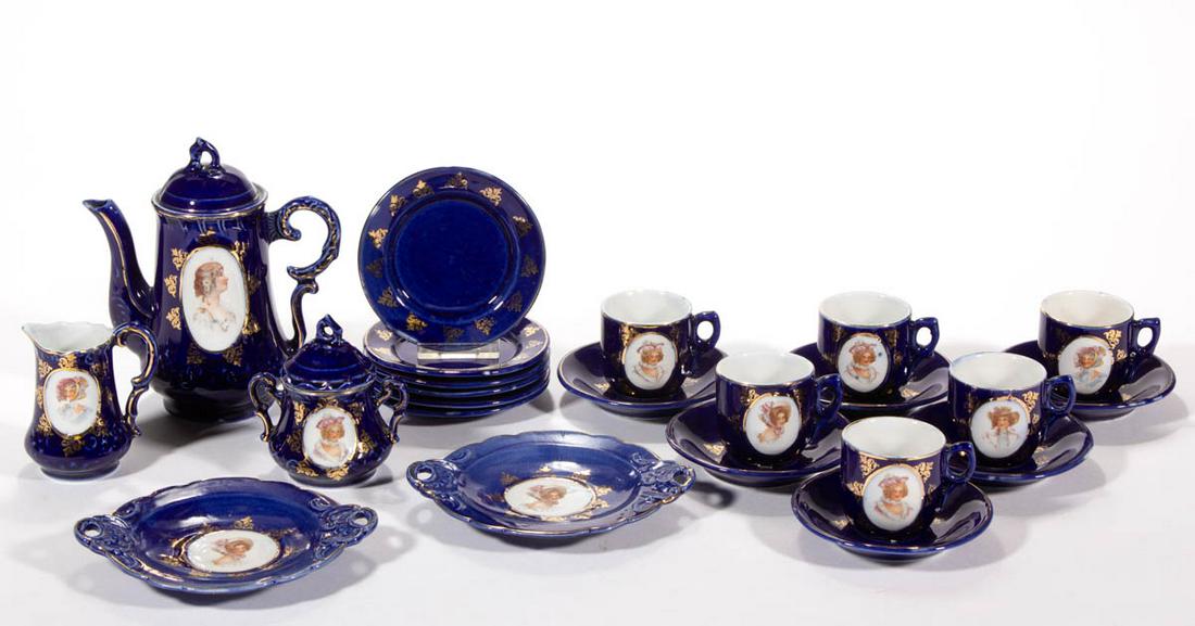 GERMAN BLUE PORTRAIT PORCELAIN 23-PIECE CHILD'S TEA SET: GERMAN BLUE PORTRAIT PORCELAIN 23-PIECE CHILD'S TEA SET, comprising a teapot, a creamer, a sugar with ill-fitting cover, two open-handled cake trays, six cup and saucer sets, and six 3 1/2" D plates,