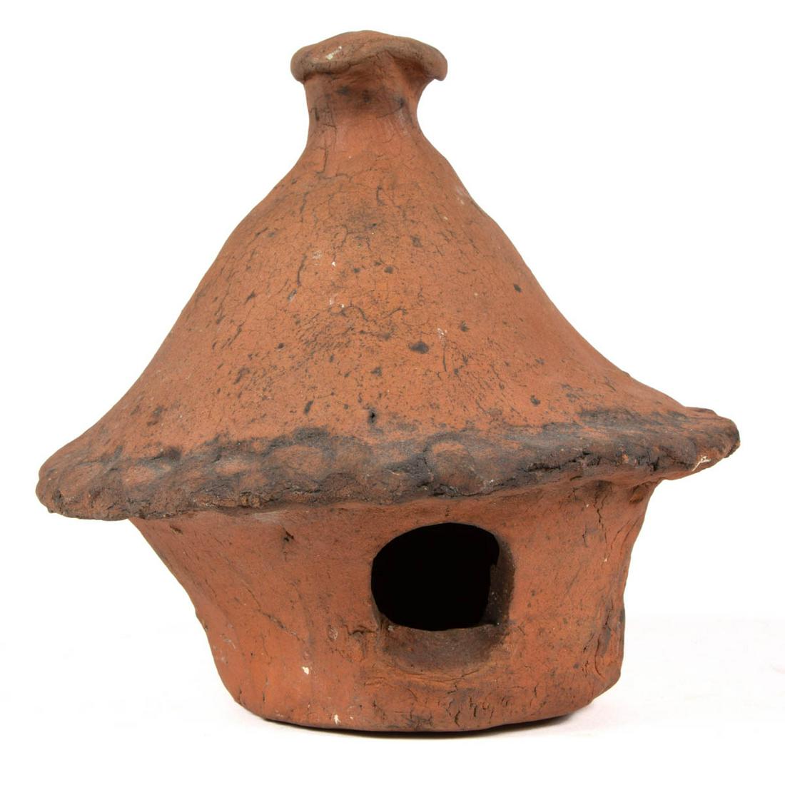 AMERICAN EARTHENWARE / REDWARE BIRDHOUSE: AMERICAN EARTHENWARE / REDWARE BIRDHOUSE, unglazed, having conical top with pie crimped rim and pronounced finial. Second half 19th century. 6 3/8" HOA.Mostly undamaged having minor chip to crimped ri