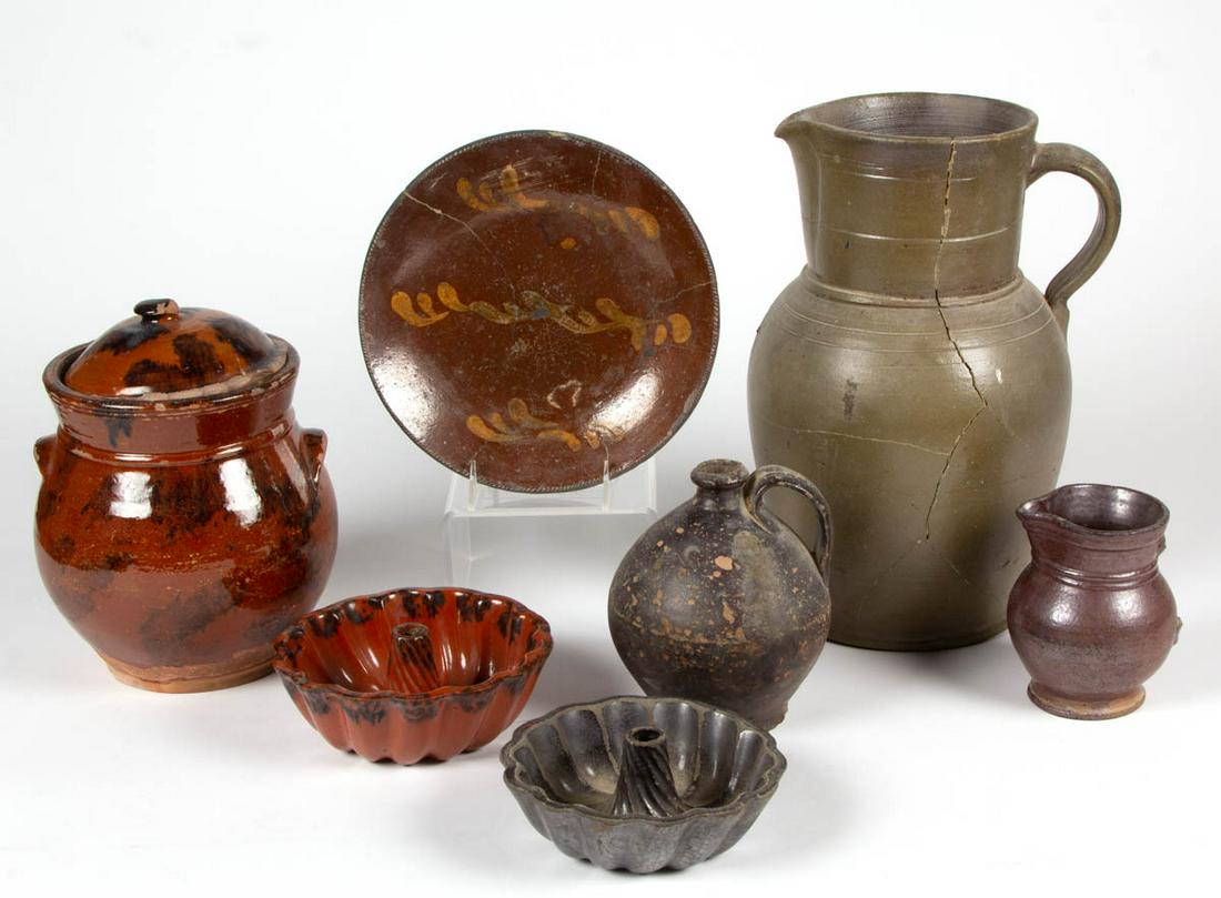 AMERICAN EARTHENWARE / REDWARE AND STONEWARE ARTICLES,: AMERICAN EARTHENWARE / REDWARE AND STONEWARE ARTICLES, LOT OF SEVEN, including two cake molds, a lead-glazed plate having yellow slip-trailed decoration, a covered redware jar with applied arched hand