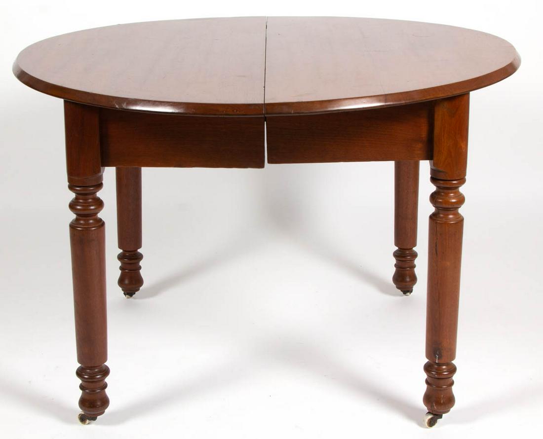 VIRGINIA WALNUT DINING TABLE: VIRGINIA WALNUT DINING TABLE, turned legs raised on casters, with three extra leaves. Old refinished surface with warm color. Second half 19th century. 29" H, 41 3/4" D top closed. Very good overall c