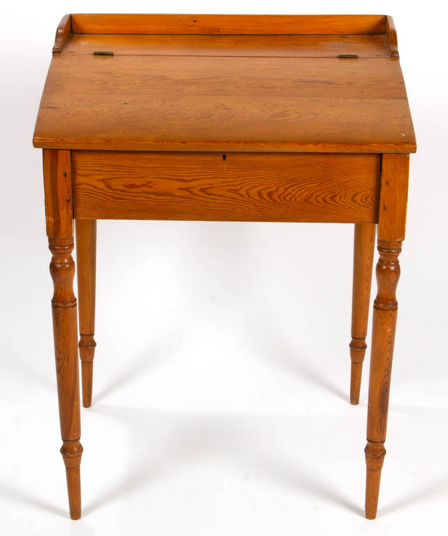 AMERICAN COUNTRY YELLOW PINE SCHOOLMASTER'S DESK: AMERICAN COUNTRY YELLOW PINE SCHOOLMASTER'S DESK, applied gallery above hinged slant-front concealing open interior, the whole raised on finely turned legs. Old refinished surface with warm color. Fir
