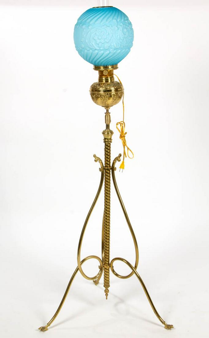 VICTORIAN STAMPED BRASS KEROSENE PIANO LAMP: VICTORIAN STAMPED BRASS KEROSENE PIANO LAMP, opaque blue to opaque white Osage pattern ball shade, stamped brass scrolling leaf and medallion font tank with a swirling stem and three looping legs term