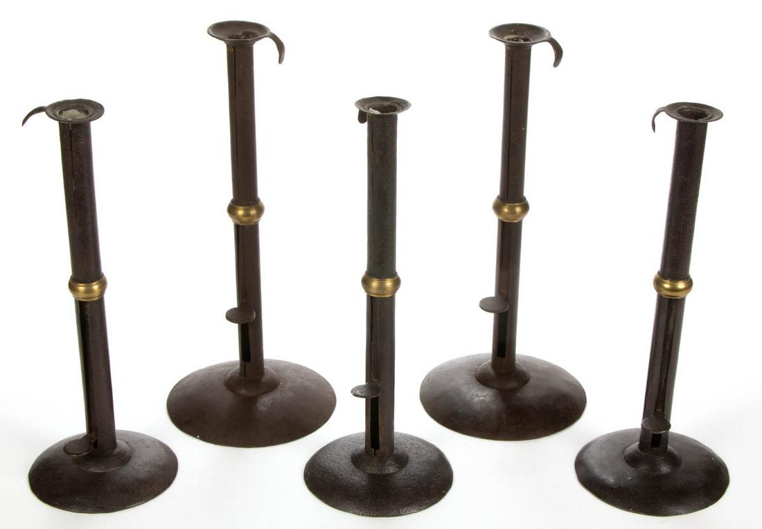 SHEET-IRON AND BRASS HOG-SCRAPER CANDLESTICKS, LOT OF: SHEET-IRON AND BRASS HOG-SCRAPER CANDLESTICKS, LOT OF FIVE, each unsigned, with circular slightly domed base supporting a straight shaft with side ejector knobs and upper hanging hooks, brass wedding 