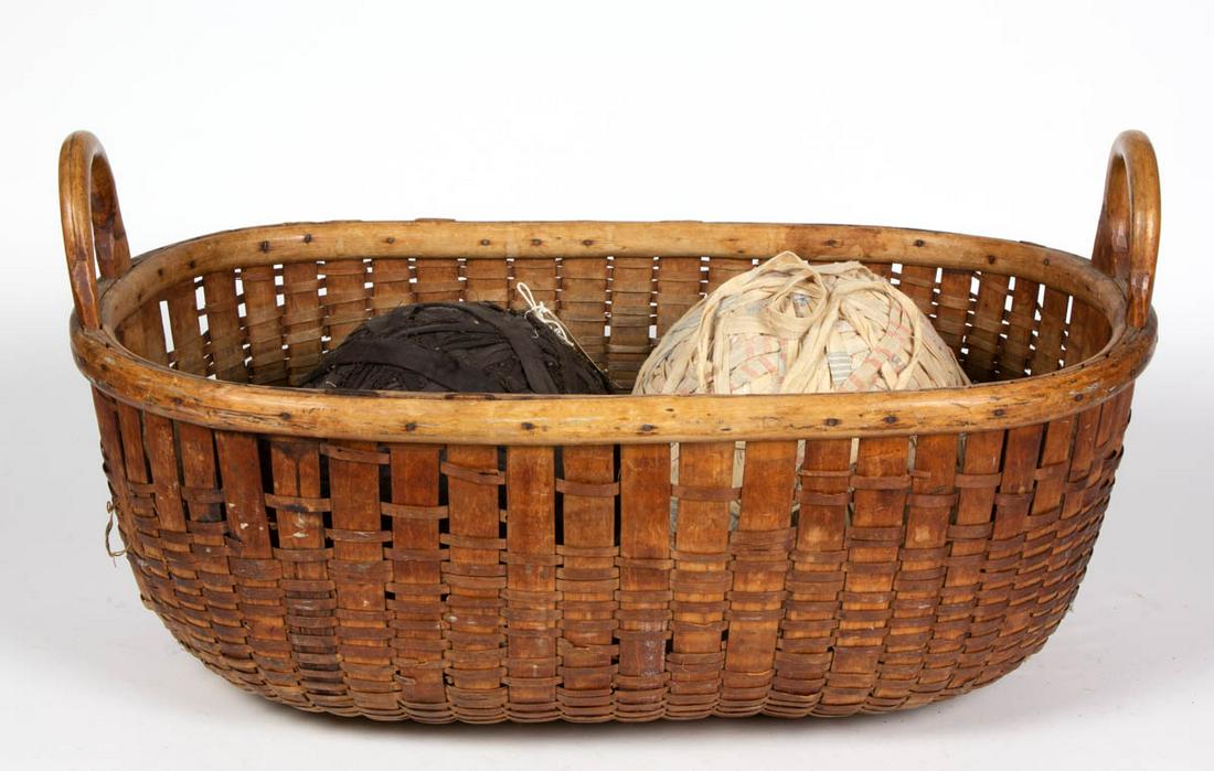 AMERICAN WOVEN-SPLINT LARGE GATHERING BASKET: AMERICAN WOVEN-SPLINT LARGE GATHERING BASKET, with two arched handles. Dry natural surface. Together with two large rag balls. Three pieces total. First quarter 20th century. 13" HOA, 25 3/4" WOA. Goo