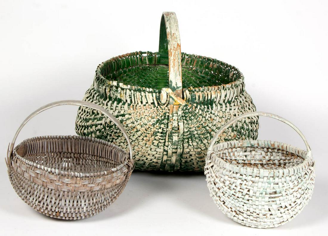 AMERICAN PAINTED WOVEN-SPLINT BASKETS, LOT OF THREE: AMERICAN PAINTED WOVEN-SPLINT BASKETS, LOT OF THREE, each kidney form with wrapped rim and arched handle. Each retains an old white-painted surface. Late 19th/early 20th century. 9 1/4" to 15 1/4" HOA