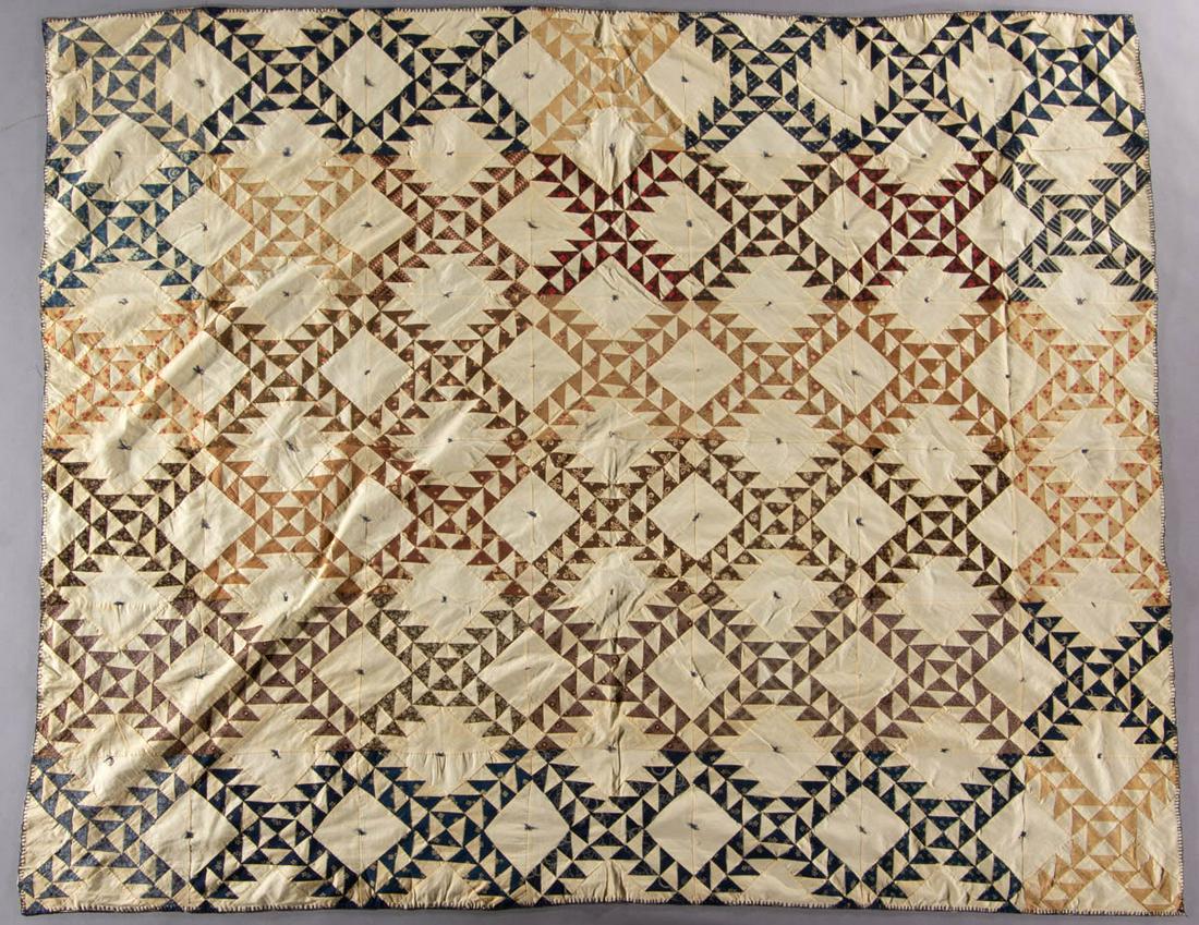 AMERICAN "LADY OF THE LAKE" PIECED AND TIED COMFORT: AMERICAN "LADY OF THE LAKE" PIECED AND TIED COMFORT, hand-stitched, various print and white fabrics, 42 pattern blocks, embroidered binding, two-panelled blue satin-type backing. Circa 1900. 74 1/2" x