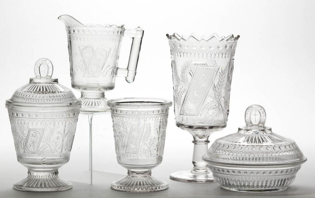GOOD LUCK / HORSESHOE FIVE-PIECE TABLE SET: GOOD LUCK / HORSESHOE FIVE-PIECE TABLE SET, colorless, comprising a covered butter dish, covered sugar bowl, creamer, spooner, and a celery vase. Fourth quarter 19th century. 5" to 8 1/2" H. Sugar cov