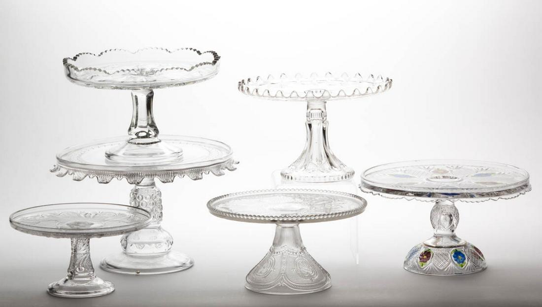 ASSORTED EAPG SALVERS / CAKE STANDS, LOT OF SIX: ASSORTED EAPG SALVERS / CAKE STANDS, LOT OF SIX, colorless, including a Heisey Locket on Chain, a Galloway, a Feather/Doric, a Button Band, and a Sunk Daisy example with polychrome-staining. Various m