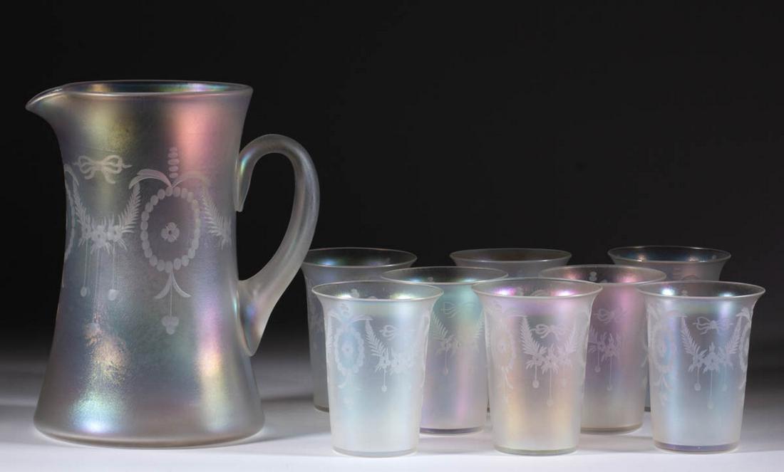 STEUBEN VERRE DE SOIE ART GLASS NINE-PIECE WATER SET: STEUBEN VERRE DE SOIE ART GLASS NINE-PIECE WATER SET, colorless iridescent, comprising a shape 1523 water pitcher and eight shape 1044 tumblers, each tumbler having a flared rim, each article having a