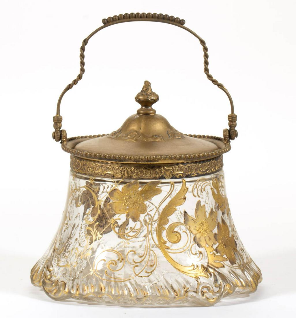 PAIRPOINT MOLDED AND GILT DECORATED CRACKER JAR: PAIRPOINT MOLDED AND GILT DECORATED CRACKER JAR, colorless with gilt decoration, having ornate scrolling and floral decoration with a molded bottom edge, signed to the underside "3929/99/PAIRPOINT", c