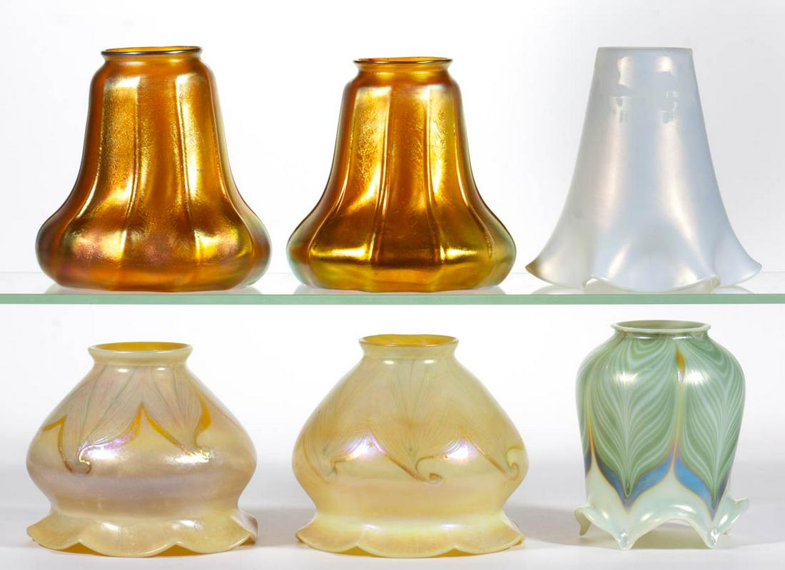 ASSORTED ART GLASS LAMP SHADES, LOT OF SIX: ASSORTED ART GLASS LAMP SHADES, LOT OF SIX, various colors, comprising two golden iridescent ribbed, three Pulled Feather examples, and a Steuben Iverene, none signed. Various makers. First quarter 20