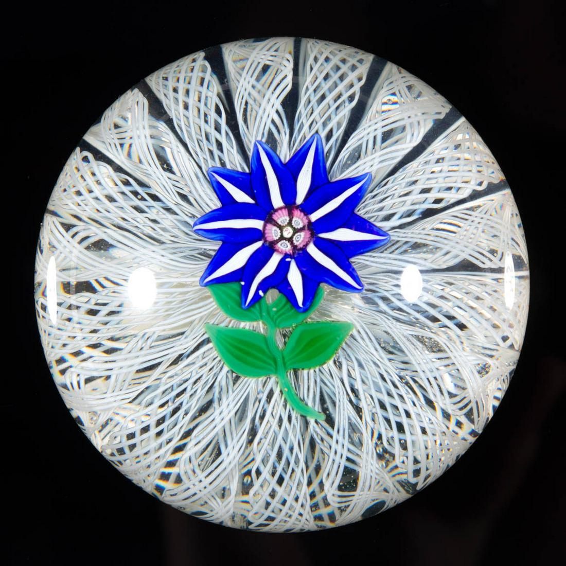 PAUL YSART CLEMATIS LAMPWORK PAPERWEIGHT: PAUL YSART CLEMATIS LAMPWORK PAPERWEIGHT, colorless, five forward blue and white petals and five blue and white petal to the background, central cane, short green stem with four leaves, all resting on