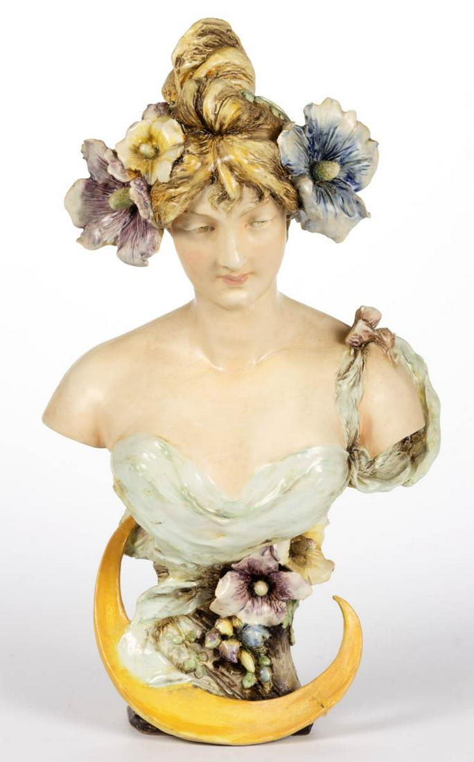AUSTRIAN / BOHEMIAN EDUARD STELLMACHER (1868-1945): AUSTRIAN / BOHEMIAN EDUARD STELLMACHER (1868-1945) TEPLITZ AMPHORA CERAMIC ART NOUVEAU BUST OF A WOMAN, having upswept hair with large flowers to sides, wearing a one shoulder low cut seafoam top with