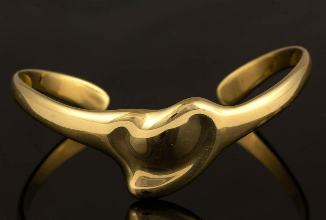ELSA PERETTI FOR TIFFANY & CO. 18K YELLOW GOLD "FULL: ELSA PERETTI FOR TIFFANY & CO. 18K YELLOW GOLD "FULL HEART" CUFF BRACELET, having a heart-shaped center, including a Tiffany & Co. blue cloth bag. Interior marked "TIFFANY & CO. / Elsa Peretti / 750 S