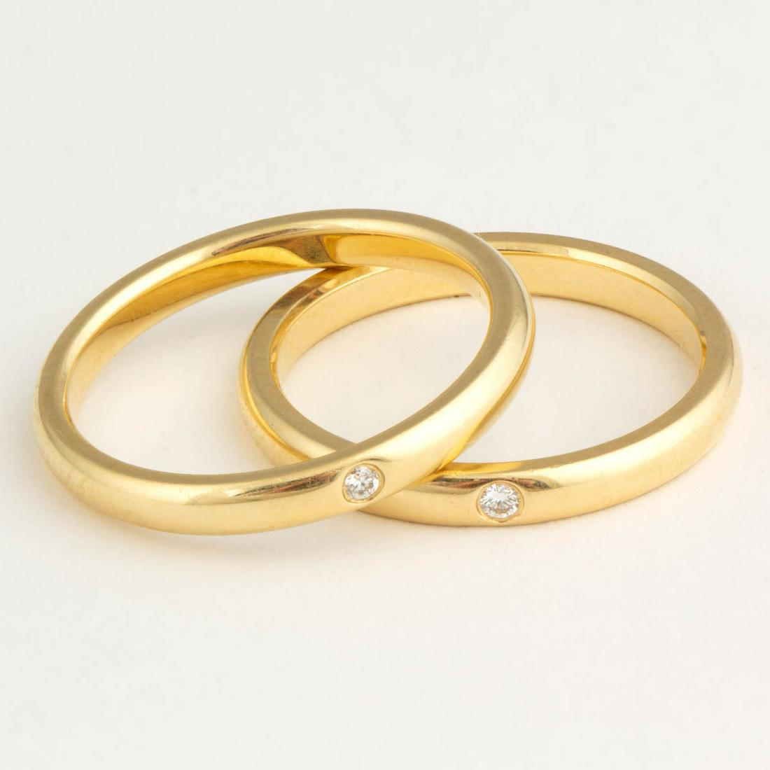 ELSA PERETTI FOR TIFFANY & CO. 18K YELLOW GOLD AND: ELSA PERETTI FOR TIFFANY & CO. 18K YELLOW GOLD AND DIAMOND STACKING BAND RINGS, SET OF TWO, each having a single round brilliant-cut diamond with an estimated weight of 0.02 ct. on a plain band. Each 
