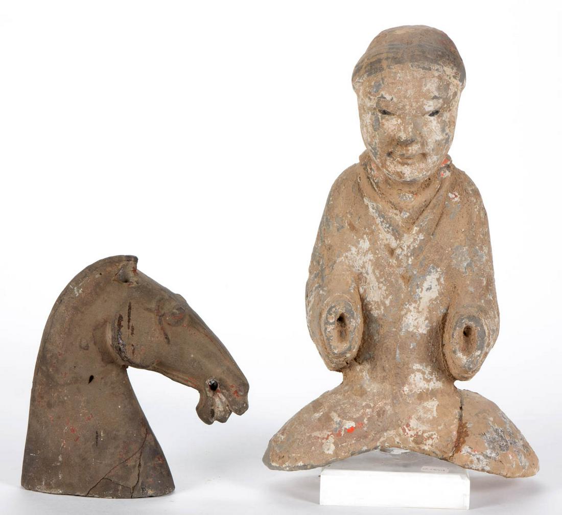 CHINESE EARTHENWARE FIGURES, LOT OF TWO: CHINESE EARTHENWARE FIGURES, LOT OF TWO, each with remnants of pigment, comprising a rider tomb figure possibly from the Western Han Dynasty, and a horse head possibly from the Tang Dynasty. One descr