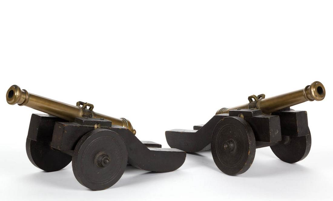 PAIR OF ANTIQUE BRASS SIGNAL CANNONS: PAIR OF ANTIQUE BRASS SIGNAL CANNONS, comprising a barrel stamped "I" and "2" with corresponding number stamped to the underside of the carriage. Carriages retain an old black-painted surfaces. 19th c