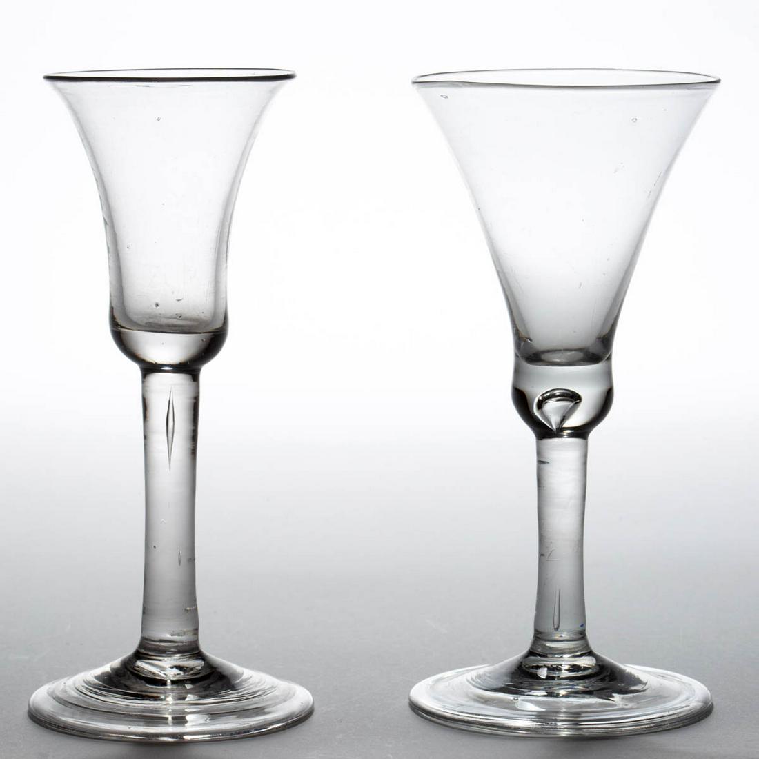 ENGLISH FREE-BLOWN PLAIN STRAIGHT STEM WINE GLASSES,: ENGLISH FREE-BLOWN PLAIN STRAIGHT STEM WINE GLASSES, LOT OF TWO, colorless lead glass, comprising a waisted bell bowl with teared solid base, and a bell bowl with solid base, each raised on a plain st